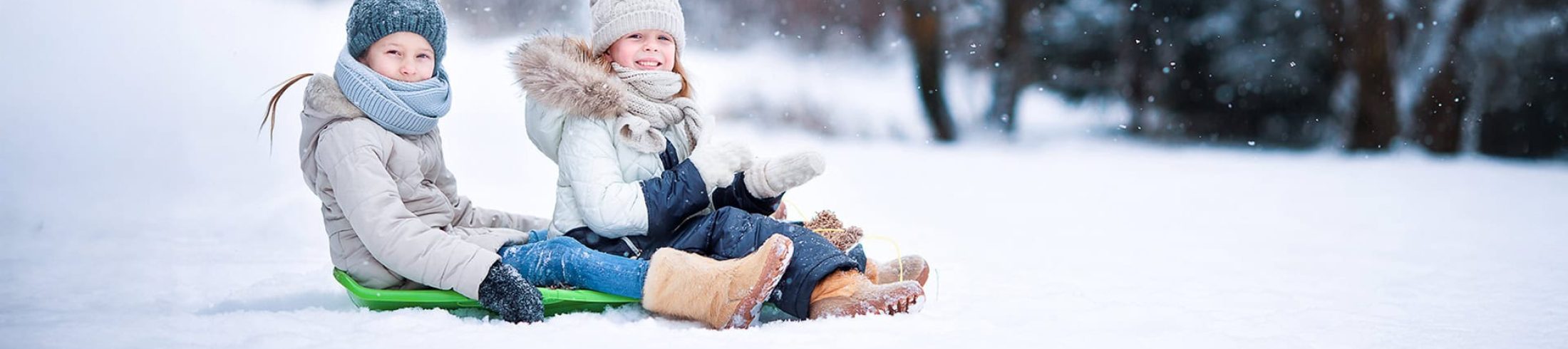 Kinder mit Schlitten im Schnee